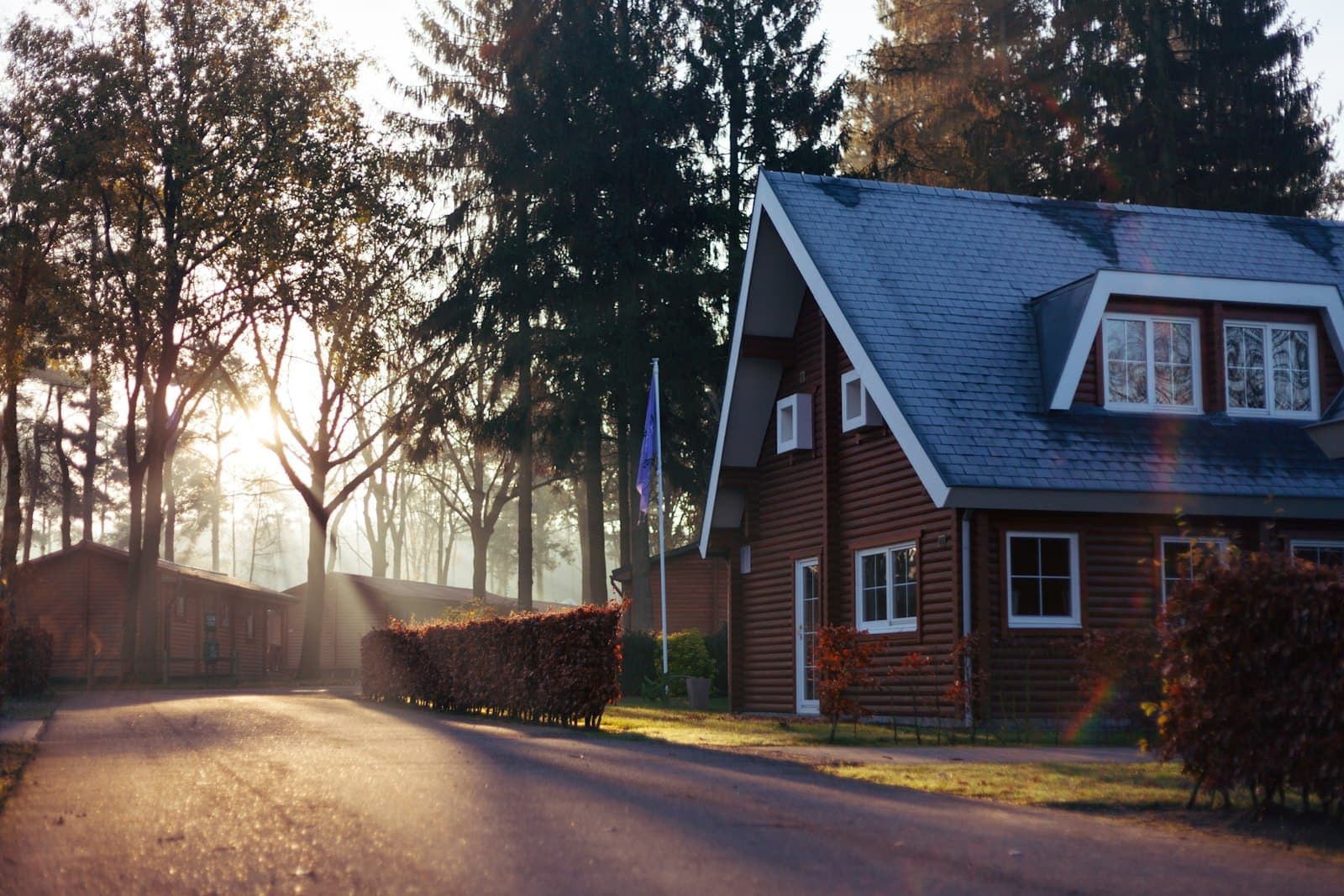 Two-storey house set back behind a garden and mature trees